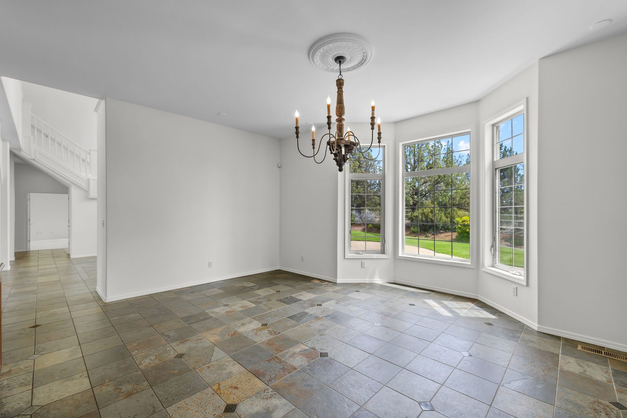 Bay-windowed dining nook with wrought-iron chandelier