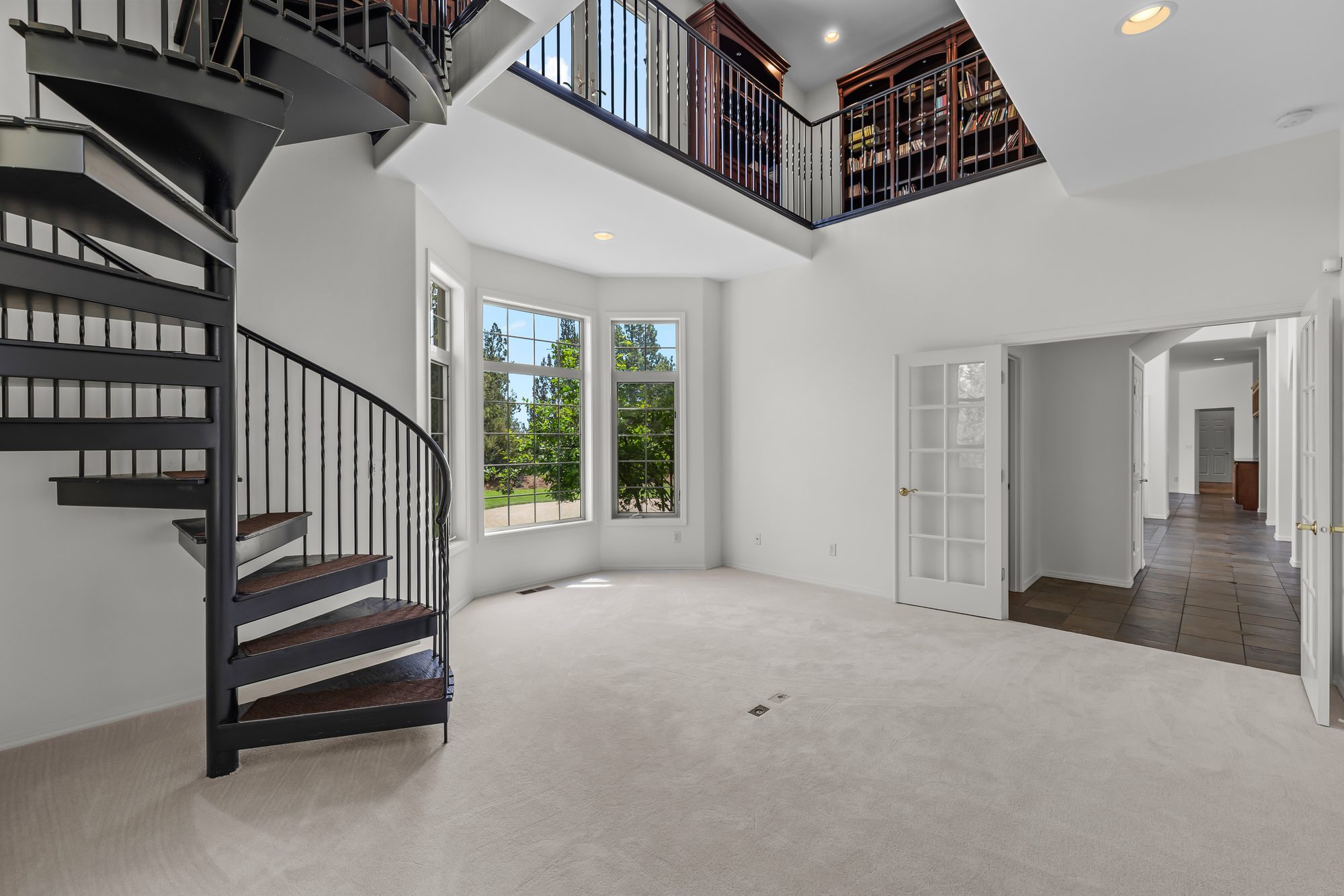 Two-story great room with spiral staircase and library loft above
