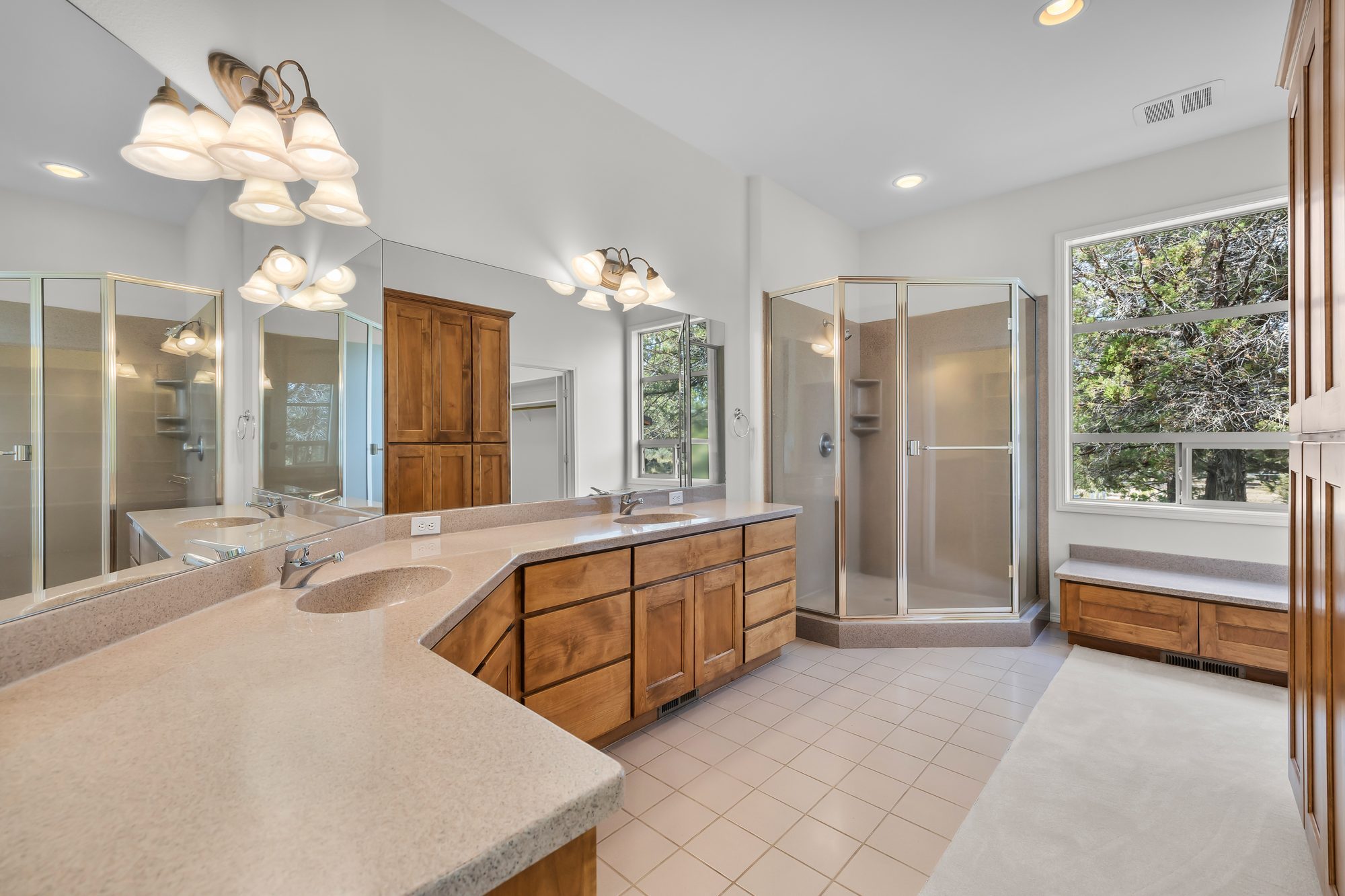 Primary bathroom with double vanity and glass-enclosed shower