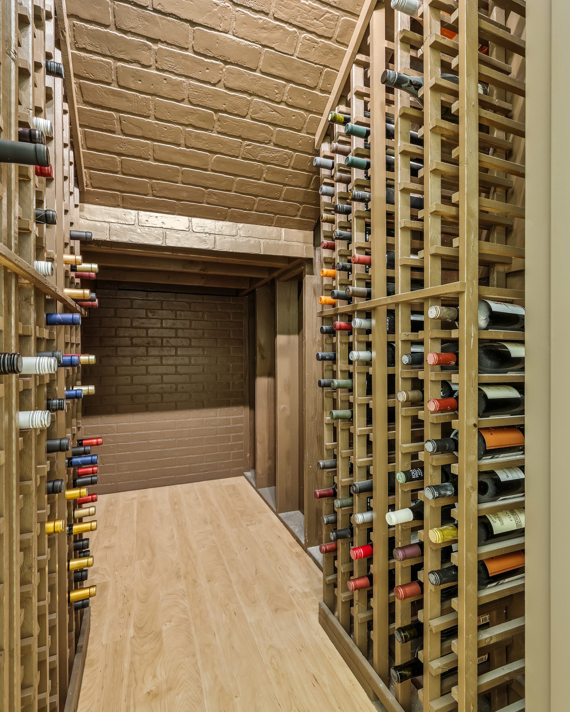 Wine cellar with floor-to-ceiling wood racking, fully stocked